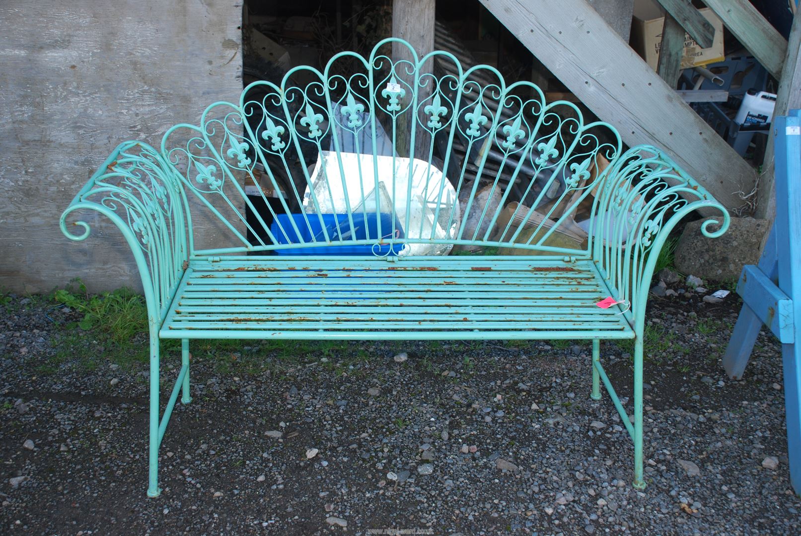 A metal fold up garden Bench with Fleur de Lys decoration, 56'' wide x 40'' high x 18'' deep.