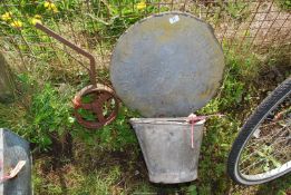 A galvanised top of an oil tank, galvanised bucket and cast iron 9'' implement wheel.
