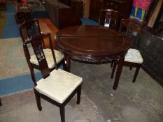 An oriental dark hardwood Chinoiserie circular Dining Table having a fretworked and carved frieze