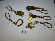 Five brass Key rings of a marine theme including anchor, propeller, pulley block,