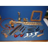 A large tray containing parts of a Hookah pipe, several "peace" pipes,