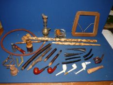 A large tray containing parts of a Hookah pipe, several "peace" pipes,