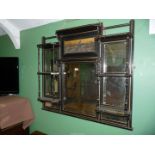 An ebonised and gilt decorated Overmantel Mirror having a bevelled mirror with a scene of