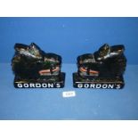 A rare and collectable opposing pair of Gordon's Gin glass advertising boar's heads,