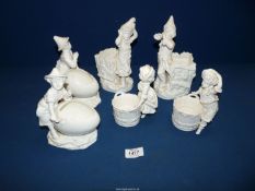 Six white ground porcelain figures of children with eggs, baskets, etc., some a/f.