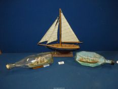 Two Ships in a bottle, one being Cutty Sark, 11" x 10" and model of yacht, 13" x 13 1/3".