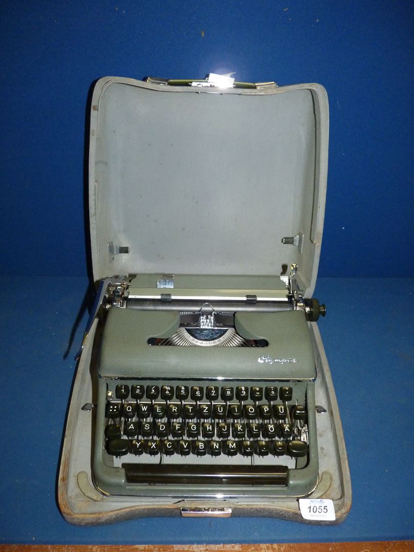 A green Olympia portable typewriter in case.