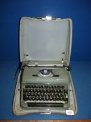 A green Olympia portable typewriter in case.