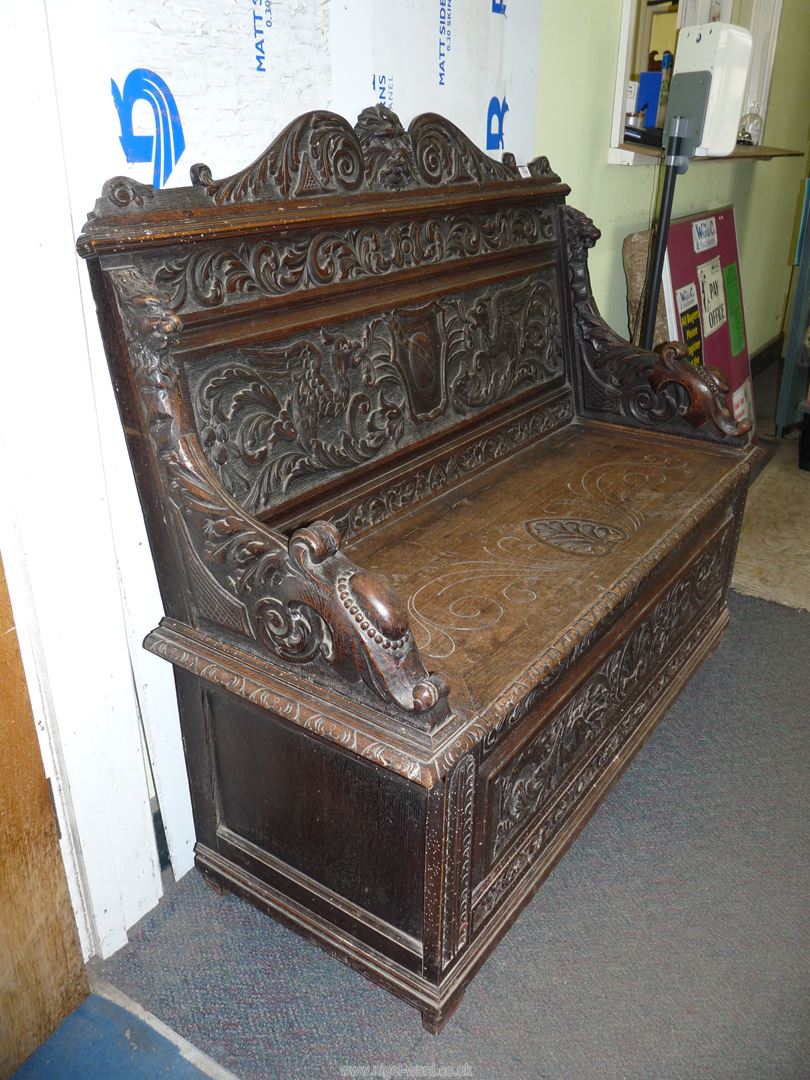 A profusely carved Oak Hall locker base Settle, the backrest with depictions of Phoenixes, - Image 9 of 9