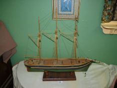 A wooden model of Sailing boat with dark green hull mounted on wooden plinth, 25 1/2" x 24 1/2".