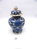 An Oriental lidded vase with blue stylised floral pattern on a white ground having two concentric