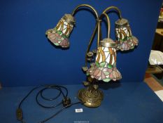 A three branch contemporary Tiffany style table lamp with three floral shades in pinks and green,