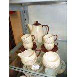 A Carlton ware part coffee set in brown and cream; 2 cups missing.