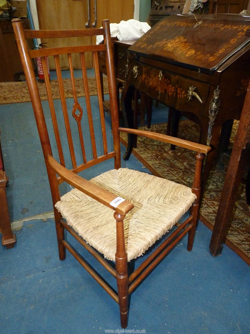 An elegant mixed woods Arts and crafts design open armed Elbow Chair having a fretworked central