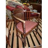 An unusual mixed woods open armed Elbow Chair having a scroll decorated carved and fretworked top