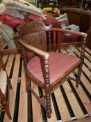 An unusual mixed woods open armed Elbow Chair having a scroll decorated carved and fretworked top