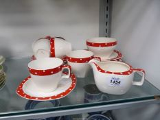 A Midwinter part tea set in cream with red rim and white spots consisting of six cups, five saucers,