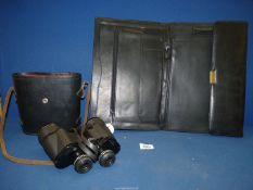 A pair of cased Prinzlux extralite 7 x 50 Binoculars and a black leather folio case.