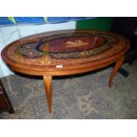 An oval continental low Occasional Table having a central depiction of a Roman Charioteer with a
