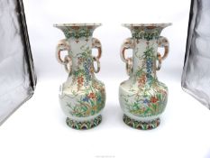 A pair of ornate vases in floral design having elephant head handles, one a/f. 14" tall.