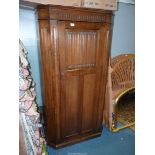 A contemporary Oak wardrobe/hall cloaks Cupboard having canted corners and a linen fold panel to