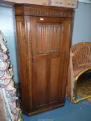A contemporary Oak wardrobe/hall cloaks Cupboard having canted corners and a linen fold panel to