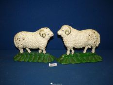 A pair of painted cast iron Doorstops modelled as sheep, 9'' wide x 6 3/4'' high.