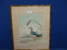 A Watercolour depicting a duck on a river bank in a bamboo effect frame and textured mount,