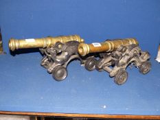 A pair of large brass Cannons on cast iron carriages with dragons to the side, on wheels, 18" long.