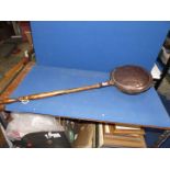 A copper bed warming pan.