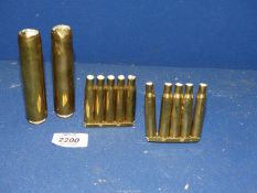 A small quantity of brass consisting of two sets of five empty bullet cases on stand,