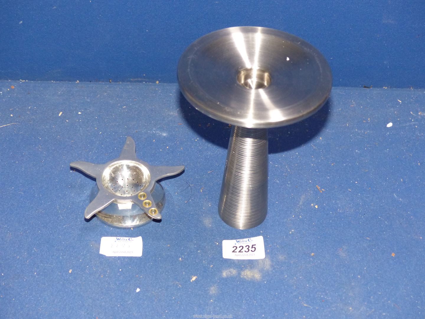 A David Mellor stainless steel candle holder and a Nick Munro pewter tea strainer and drip tray.