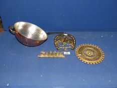A brass horseshoe key rack, rabbit key rack, trivet and copper coated colander.
