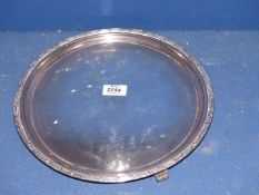 A large Silver circular serving Platter on three feet with geometric pattern rim, Sheffield 1937,