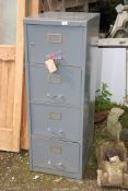 A metal four drawer filing cabinet with key.