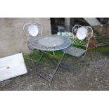 A metal circular folding table, 27 1/2'' diameter x 28'' high and matching pair of chairs.