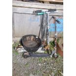 Three children's scooters and a wooden barrel planter.