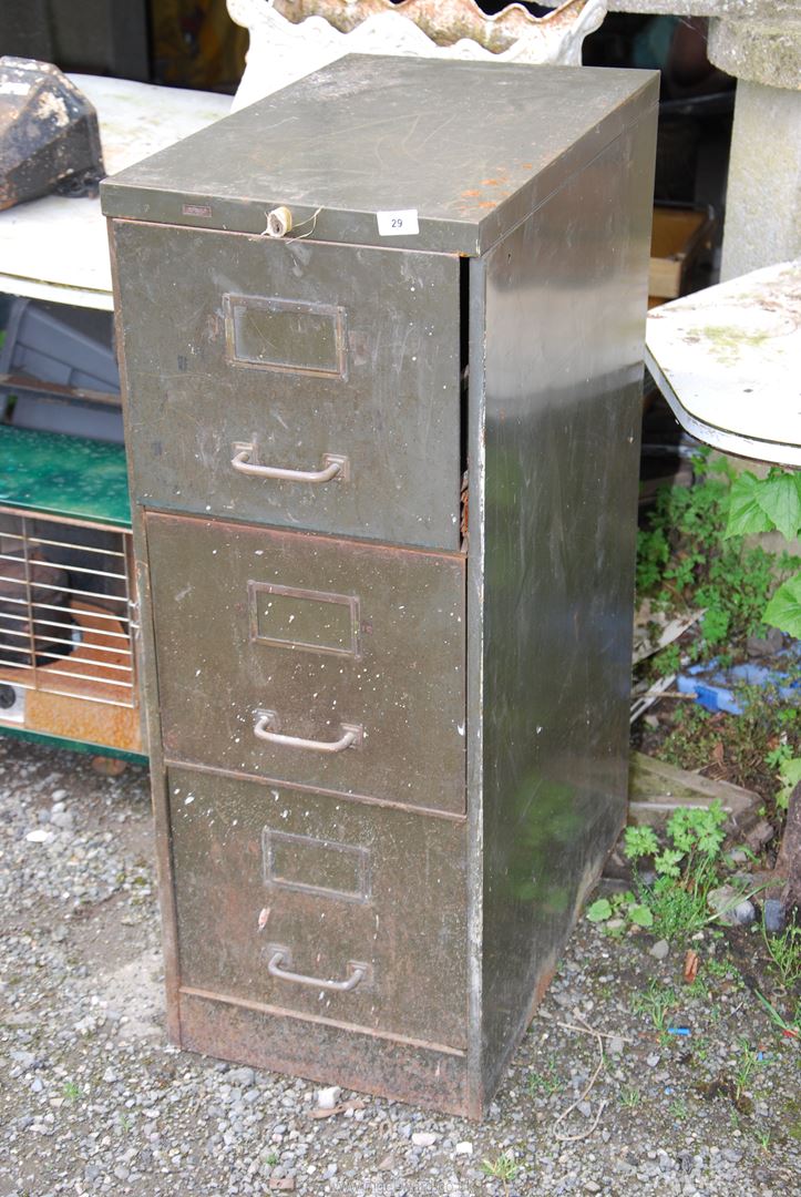 A green metal three drawer filing cabinet.