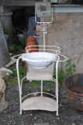 A wrought iron campaign type washstand with china bowl and swing mirror.