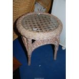 A circular wicker table with glass top, 22" diameter x 22 1/2" high.