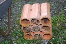 A bug hotel made from clay pipes.