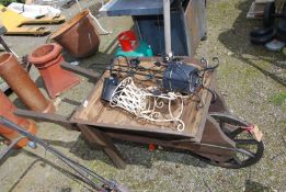 A wooden wheelbarrow and pot stand.