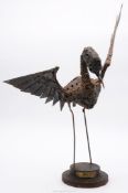 A heavy metal "Walenty Pytel" Bird sculpture having outstretched wings on a raised stepped circular