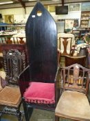 A dark stained wood high backed armchair of ecclesiastic flavour having a solid wood seat and also