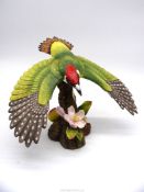 A limited edition figure of a Woodpecker landing on a branch with apple blossom and cider apple,