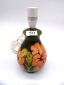 A Moorcroft table lamp in Hibiscus pattern.
