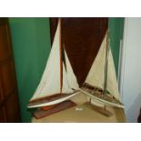 Two wooden model sailing yachts, botth on wooden plinths: 15'' x 21 1/2'' tall and 13'' x 19'' tall.