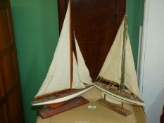 Two wooden model sailing yachts, botth on wooden plinths: 15'' x 21 1/2'' tall and 13'' x 19'' tall.