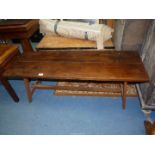 A rectangular low Oak Table, the splayed feet united by a central stretcher retained by pegs,