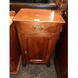 A Mahogany and Elm Bedside Cabinet having a frieze drawer and recessed panelled door below,